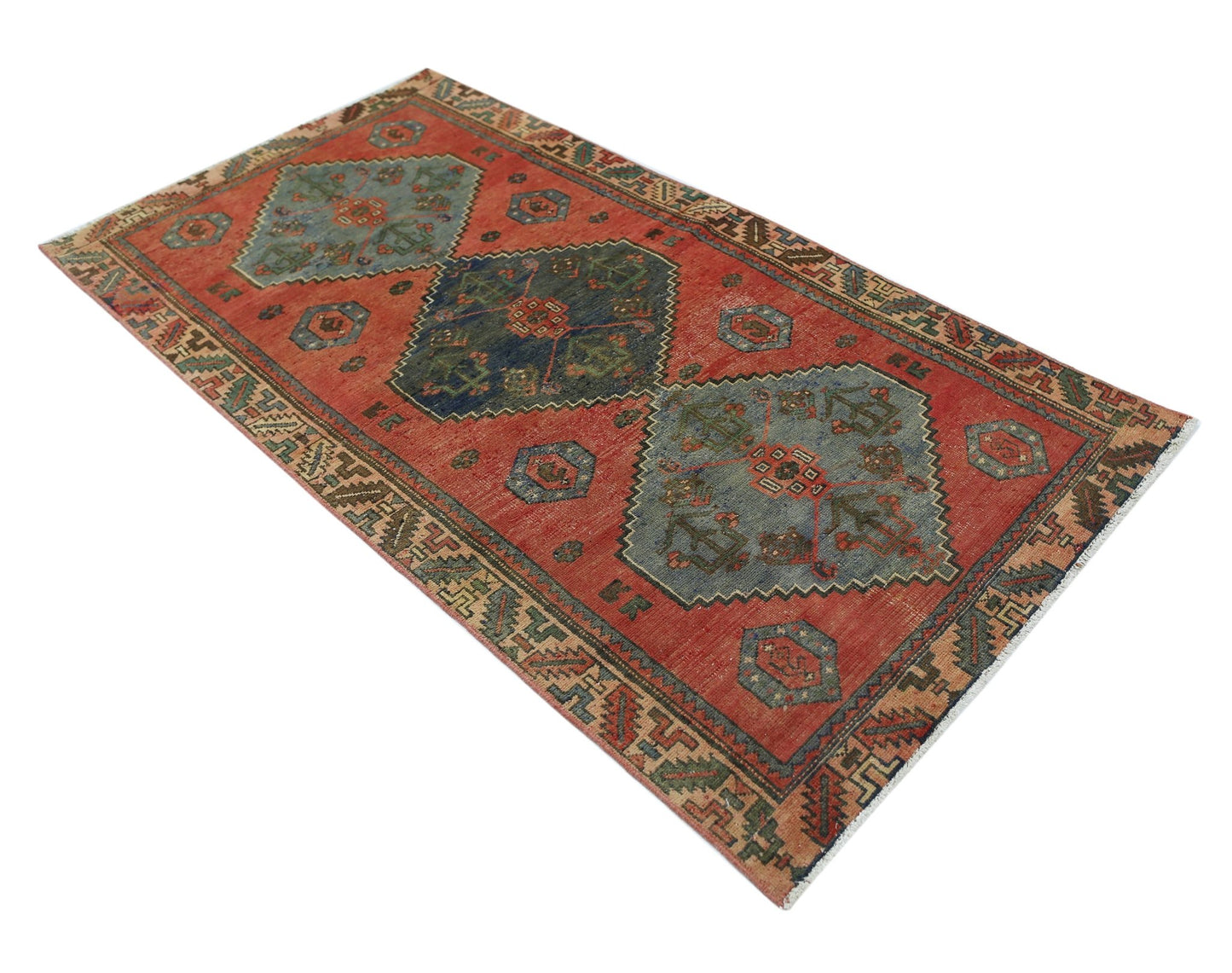 A vintage Persian Afshar rug featuring geometric medallions in blue and green on a red field.