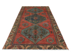 A vintage Persian Afshar rug featuring geometric blue medallions on a red field with patterned borders.