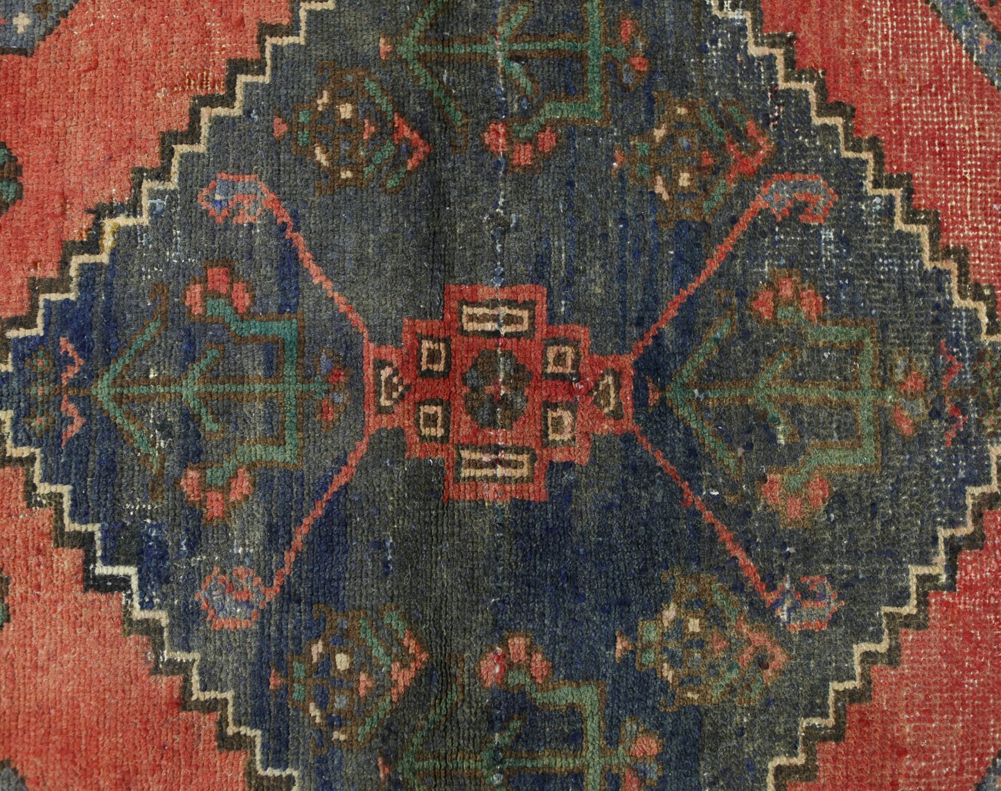 A vintage Persian Afshar rug featuring a dark blue central medallion with geometric floral motifs.