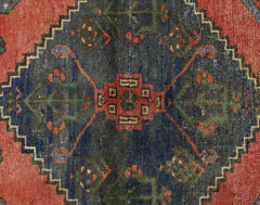 A vintage Persian Afshar rug featuring a dark blue central medallion with geometric floral motifs.