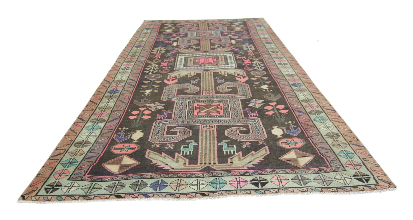 A vintage Persian Ardabil rug featuring geometric patterns and animal motifs in a dark colorway.