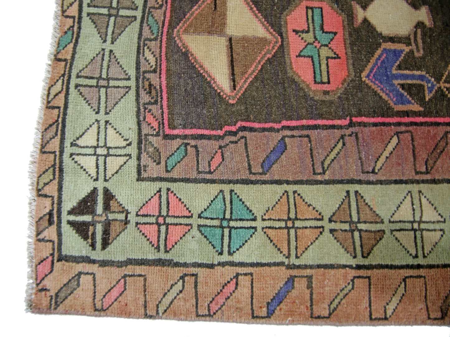 A vintage Persian Ardabil rug featuring geometric patterns in a vibrant, multi-colored palette.