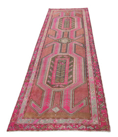 A vintage Persian Ardabil runner rug featuring geometric patterns in shades of pink and olive green.
