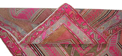 A vintage Persian Ardabil rug featuring a geometric pattern in vibrant pink and brown tones.