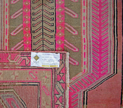 A vintage Persian Ardabil rug featuring geometric patterns in vibrant pink and earthy brown tones.