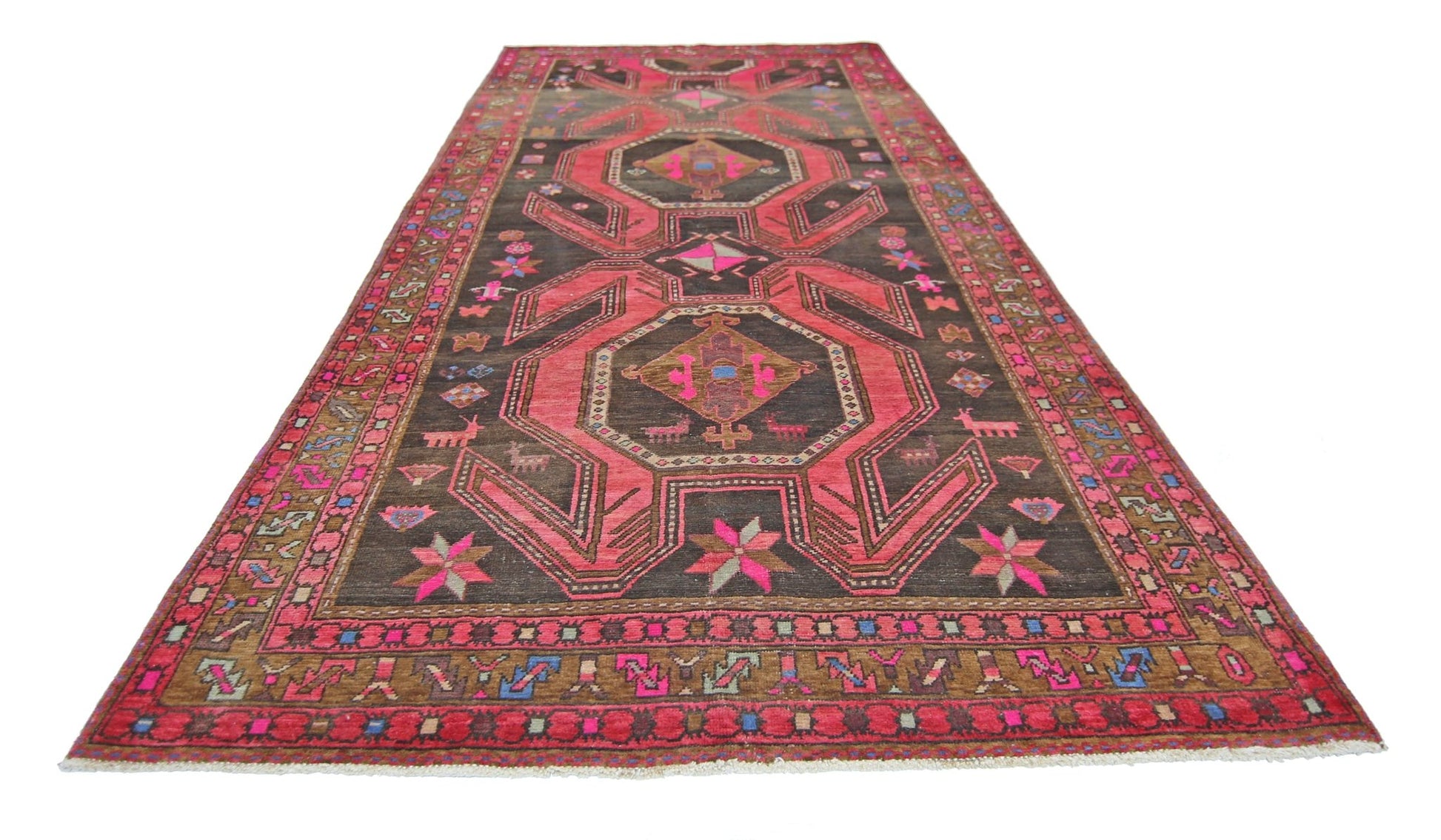 A vintage Persian Ardabil rug featuring a dark brown field with vibrant pink geometric patterns.