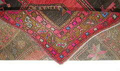 A vintage Persian Ardabil rug featuring a geometric pattern in vibrant red, brown, and pink tones.