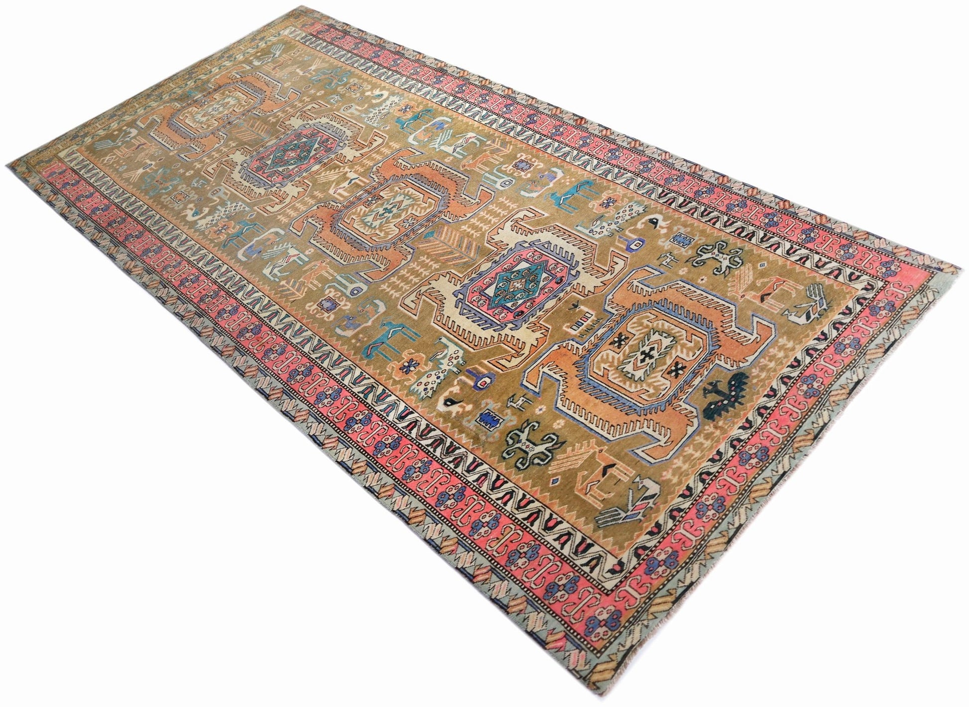 A vintage Persian Ardabil rug featuring geometric medallions on a tan field with pink borders.