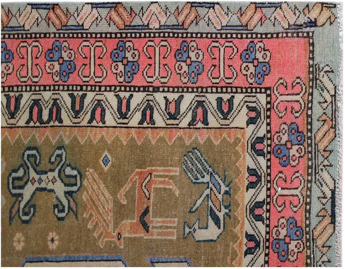 A vintage Persian Ardabil rug featuring geometric animal motifs and floral borders in muted tones.