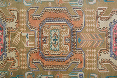 A vintage Persian Ardabil rug featuring a geometric central medallion in orange and blue tones.