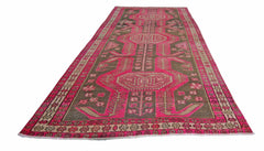 A vintage Persian Ardabil runner rug featuring a geometric pink and brown pattern.
