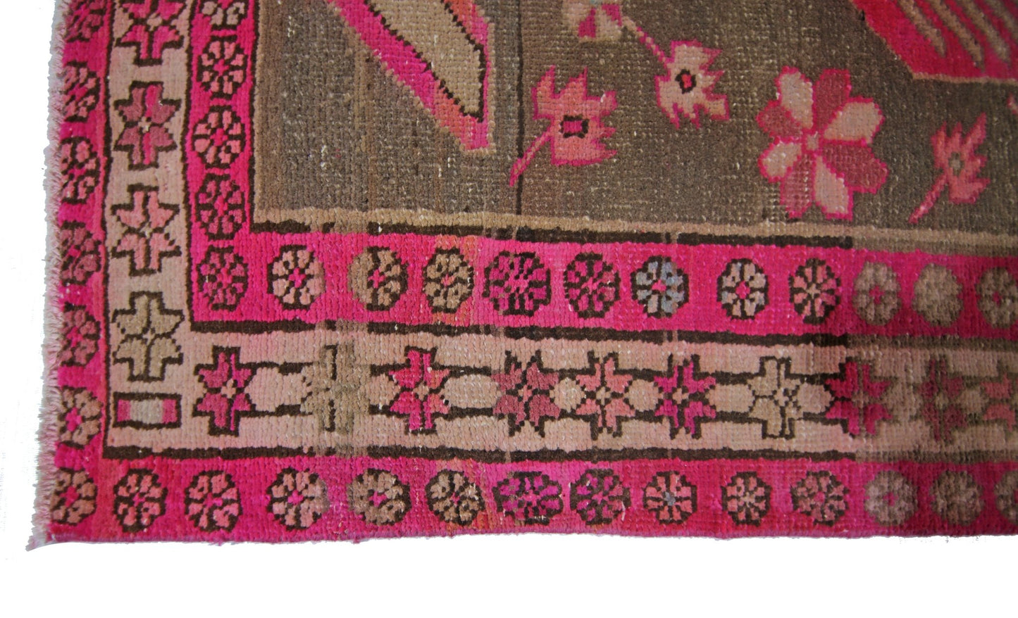 A vintage Persian Ardabil rug featuring a geometric floral border in vibrant pink and brown tones.
