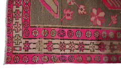 A vintage Persian Ardabil rug featuring a geometric floral border in vibrant pink and brown tones.
