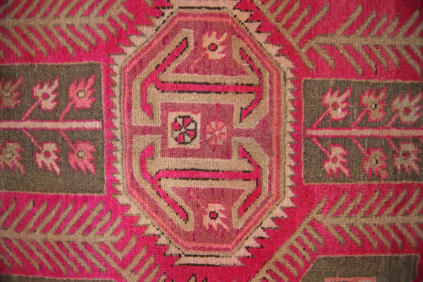 A vintage Persian Ardabil rug featuring a geometric central medallion in vibrant pink and brown.