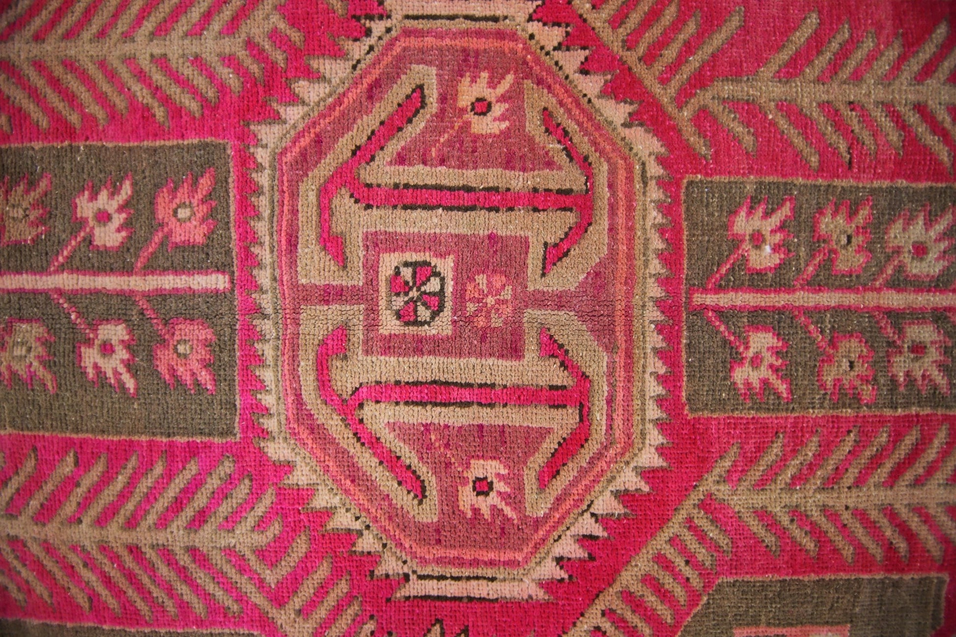 A vintage Persian Ardabil rug featuring a geometric central medallion in vibrant pink and brown.
