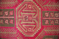 A vintage Persian Ardabil rug featuring a geometric central medallion in vibrant pink and brown.