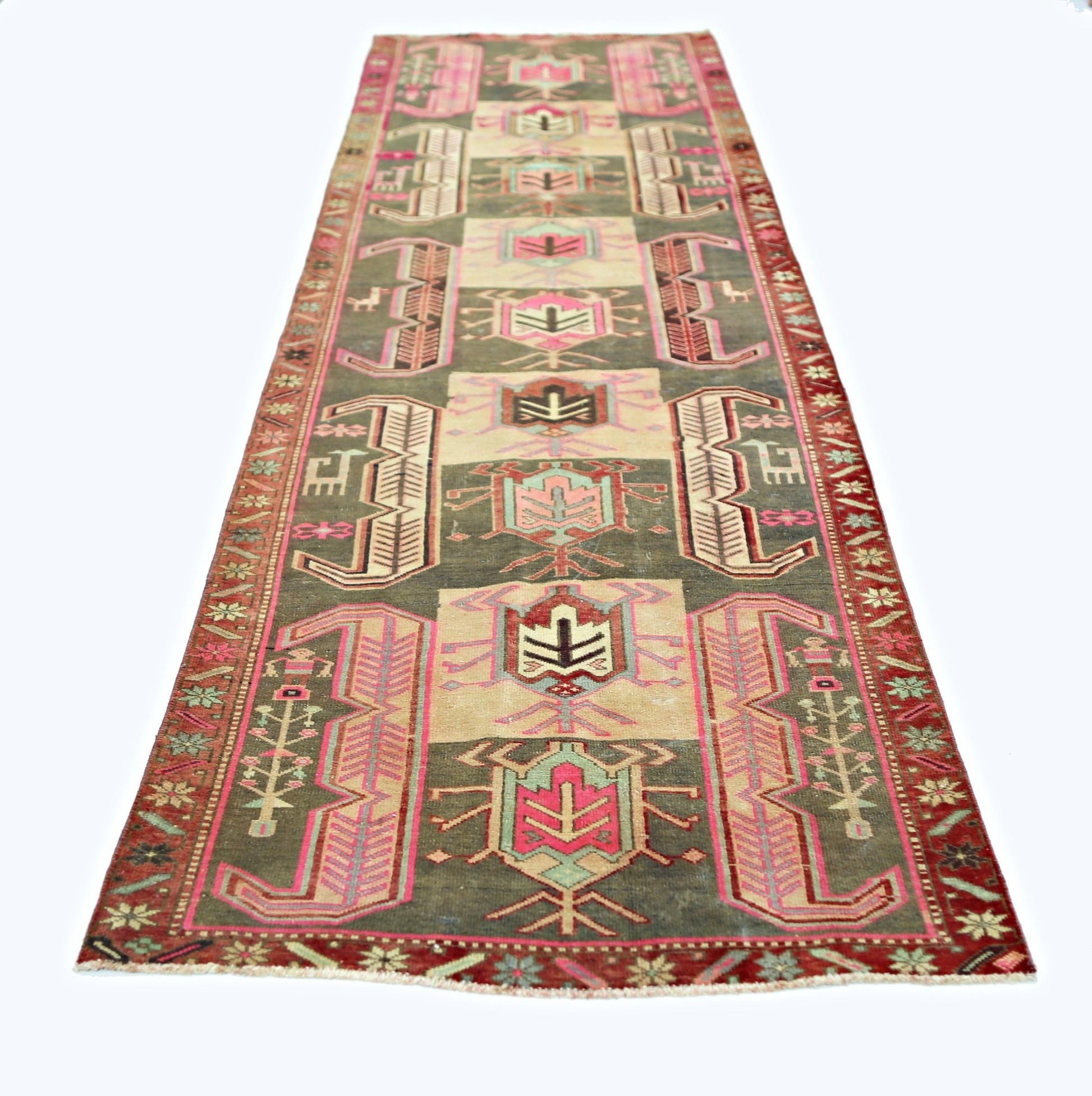 A vintage Persian Ardabil runner featuring geometric tribal motifs in muted tones on a dark field.