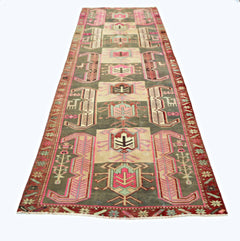 A vintage Persian Ardabil runner featuring geometric tribal motifs in muted tones on a dark field.