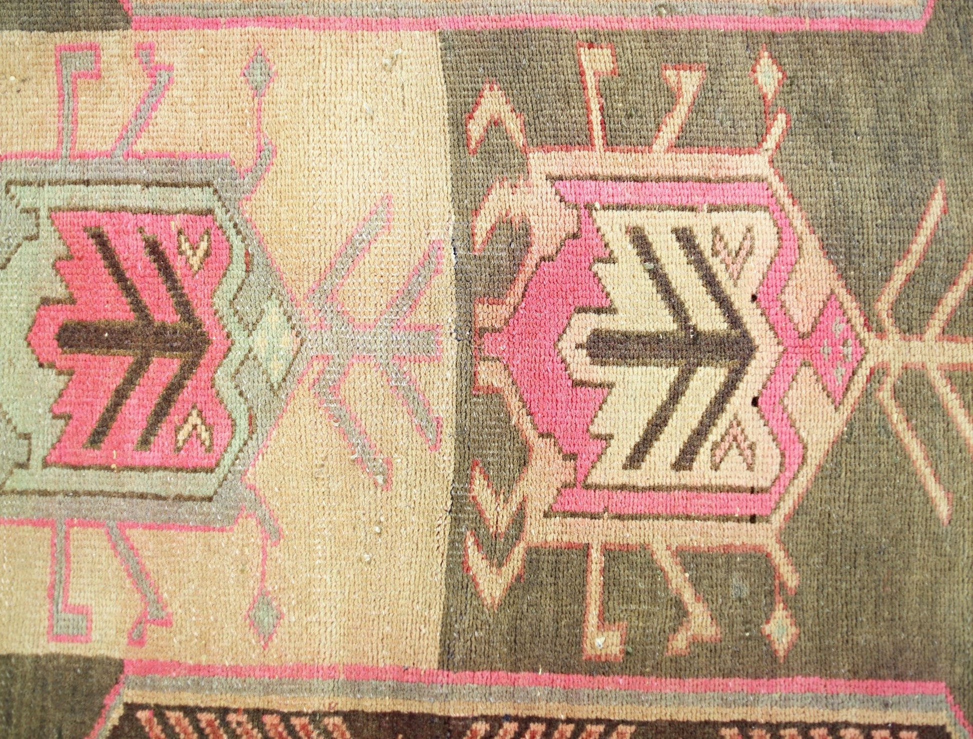 A vintage Persian Ardabil runner featuring geometric medallions in pink, brown, and cream tones.