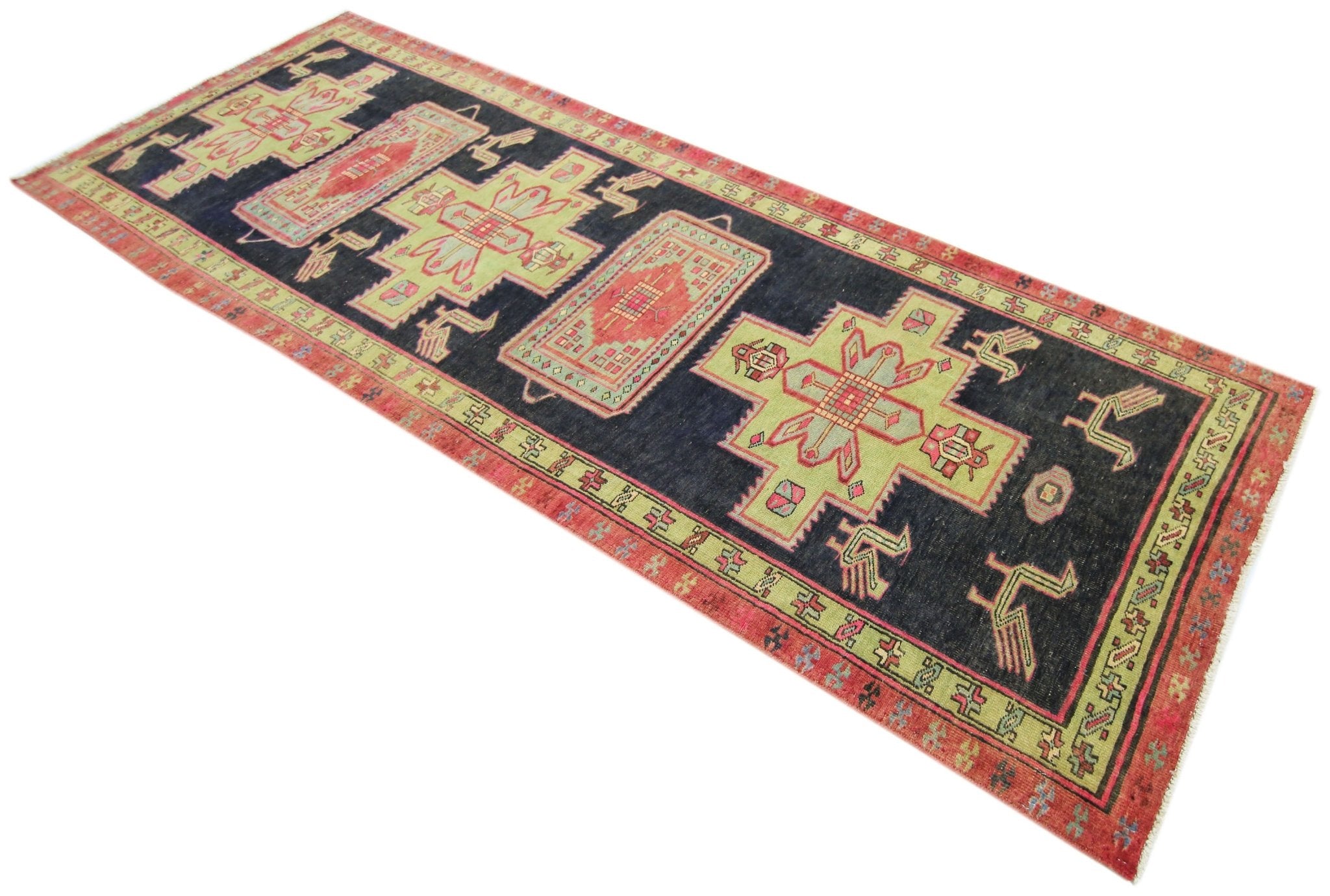 A vintage Persian Ardabil runner featuring geometric motifs in red, green, and dark blue.