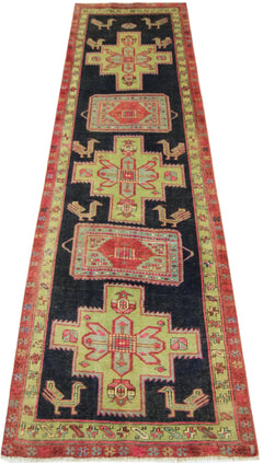 A vintage Persian Ardabil runner featuring geometric green medallions and bird motifs on black.