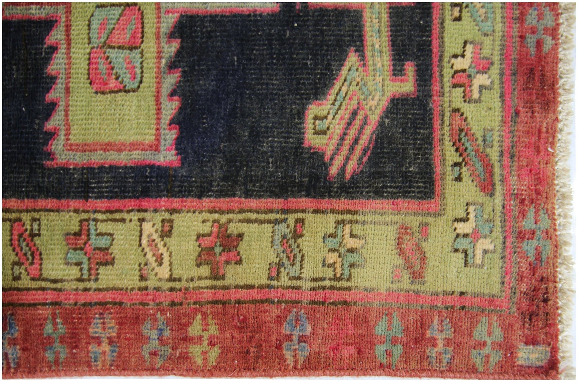 A vintage Persian Ardabil runner featuring geometric patterns in red, green, and dark blue.