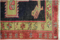 A vintage Persian Ardabil runner featuring geometric patterns in red, green, and dark blue.