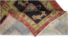 A vintage Persian Ardabil runner with a geometric pattern in red, green, and black wool.