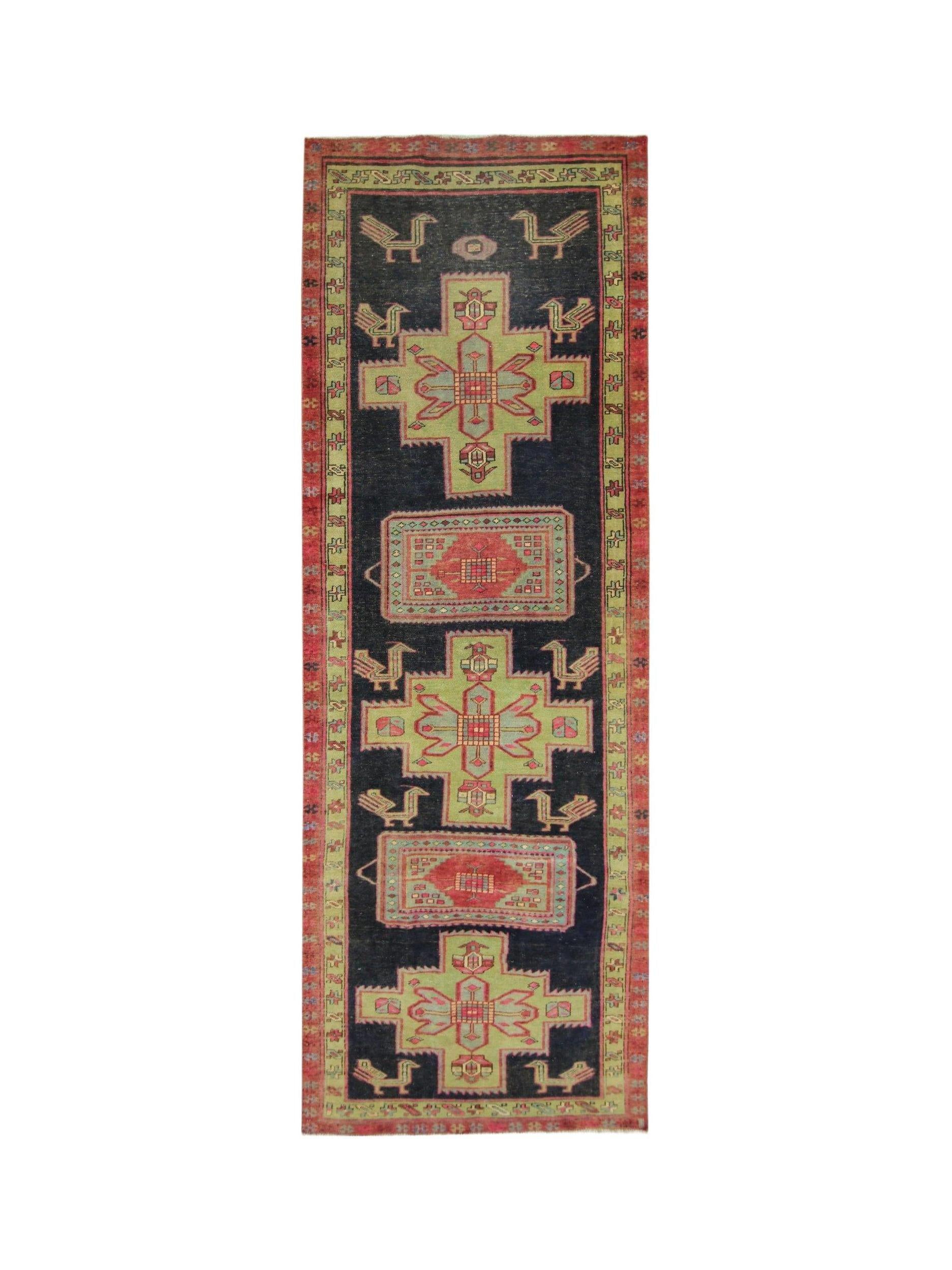 A vintage Persian Ardabil runner featuring geometric green and red medallions on a black field.