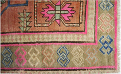 A vintage Persian runner featuring geometric patterns in pink, blue, and tan on a wool pile.
