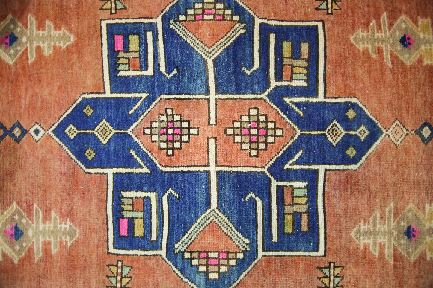 A vintage Persian runner featuring a geometric blue and orange medallion pattern.
