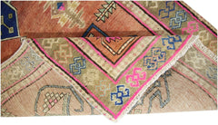 A vintage Persian runner featuring geometric patterns in orange, blue, and pink on a wool pile.