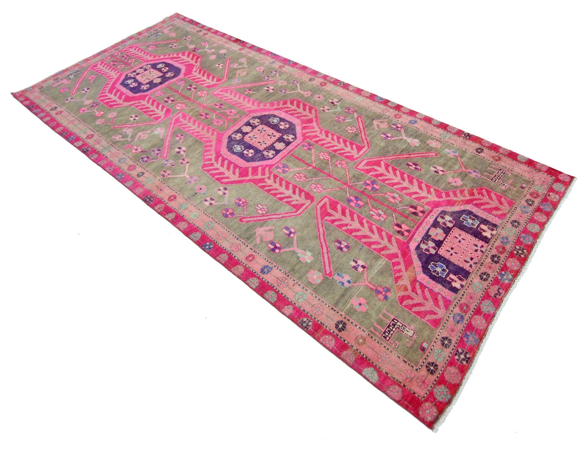 A vintage Persian Ardabil rug featuring a geometric pattern in vibrant pink and purple on a grey field.