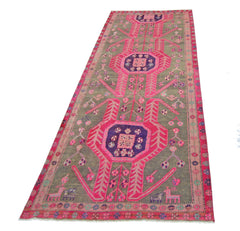A vintage Persian Ardabil runner rug featuring geometric pink and purple motifs on a grey field.