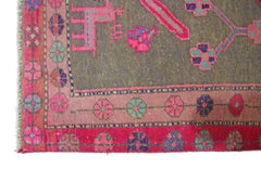 A vintage Persian Ardabil rug featuring a grey field with vibrant pink, purple, and green motifs.