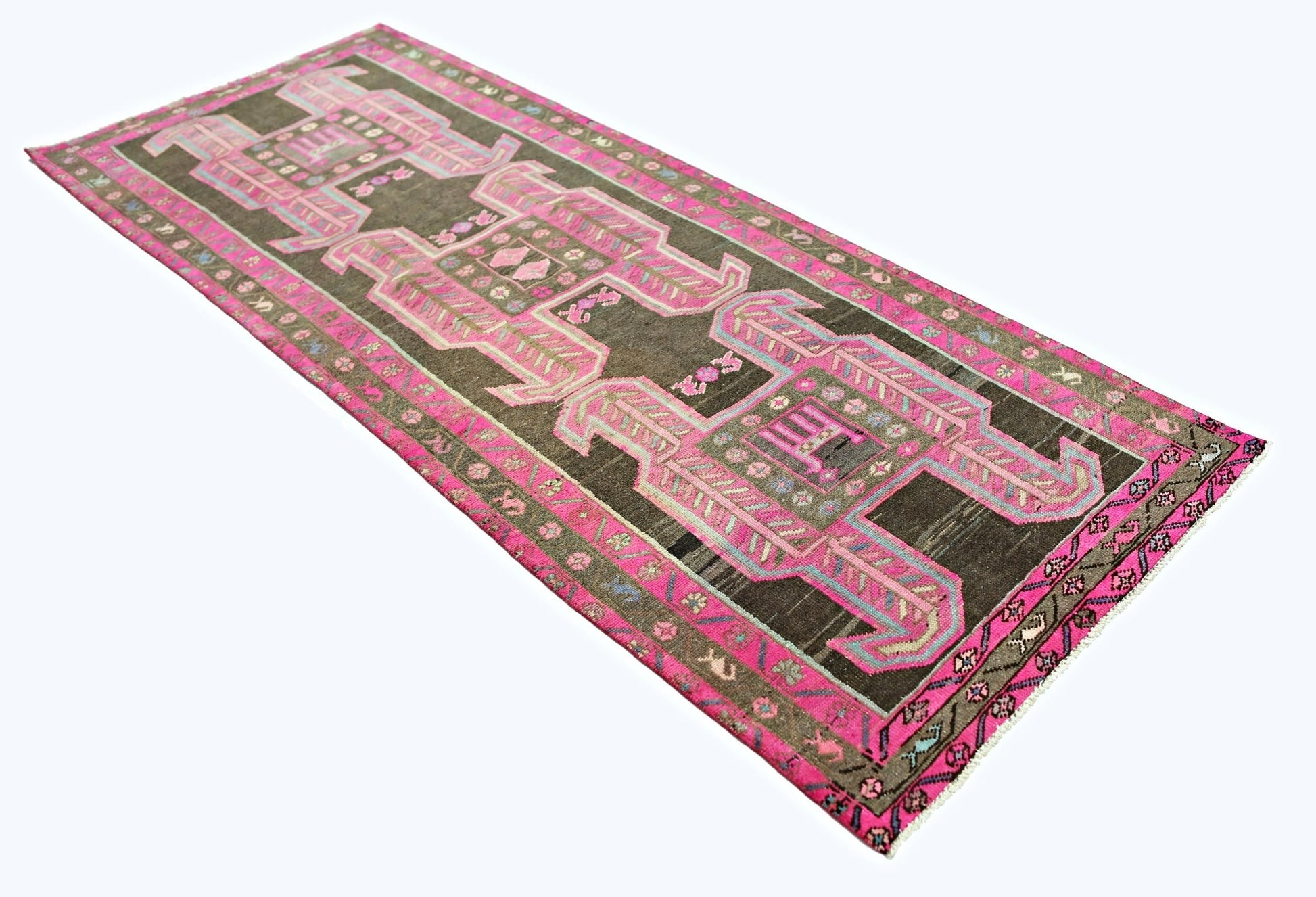 A vintage Persian Ardabil runner featuring geometric pink patterns on a dark brown wool field.