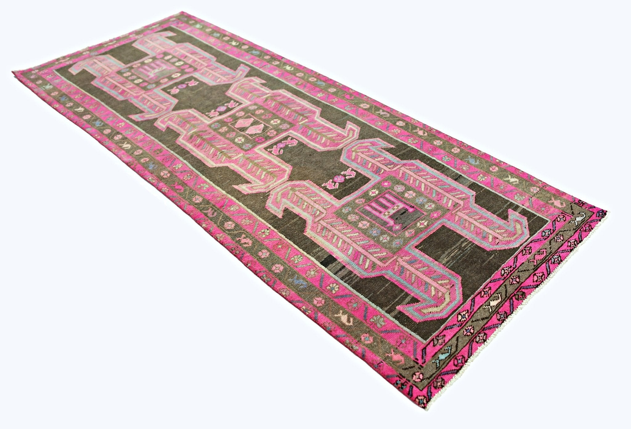 A vintage Persian Ardabil runner featuring geometric pink patterns on a dark brown wool field.