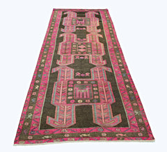 A vintage Persian Ardabil runner featuring geometric pink motifs on a dark brown background.