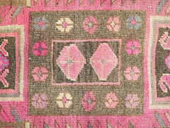 A vintage Persian Ardabil runner featuring a brown field with pink floral motifs and geometric shapes.