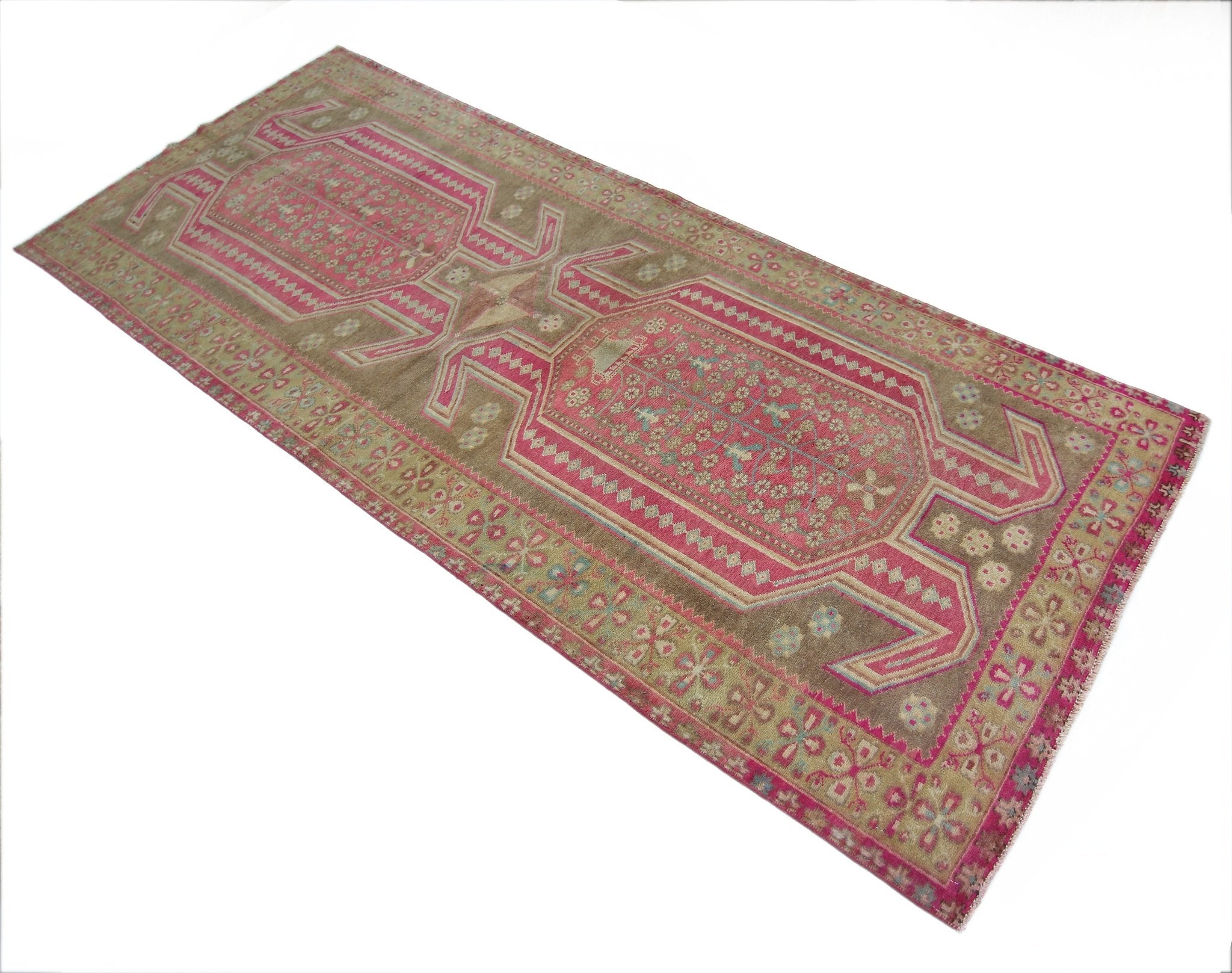 A vintage Persian Ardabil rug featuring a geometric pink and brown floral pattern.