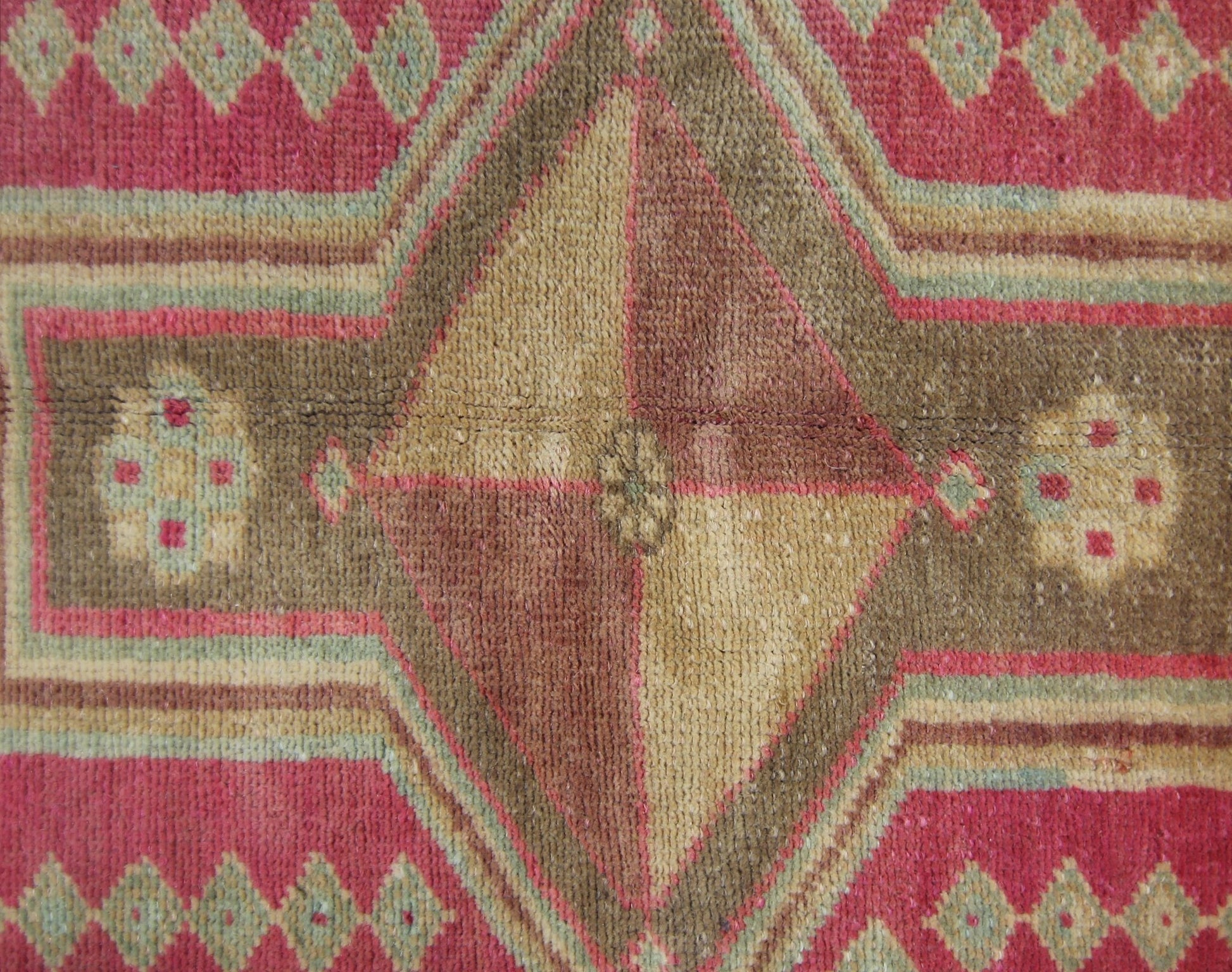 A vintage Persian Ardabil rug featuring a central diamond motif in shades of brown and tan.