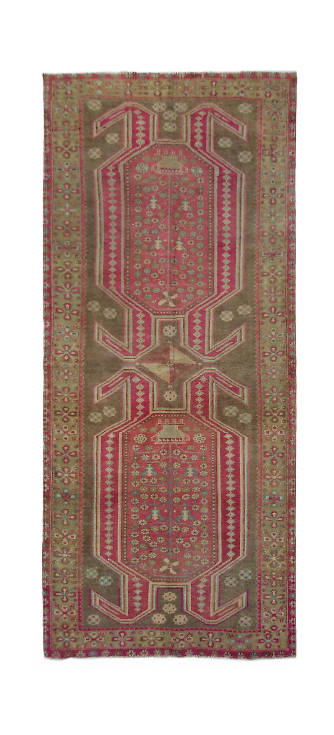 A vintage Persian Ardabil rug featuring a geometric pink and brown floral pattern.
