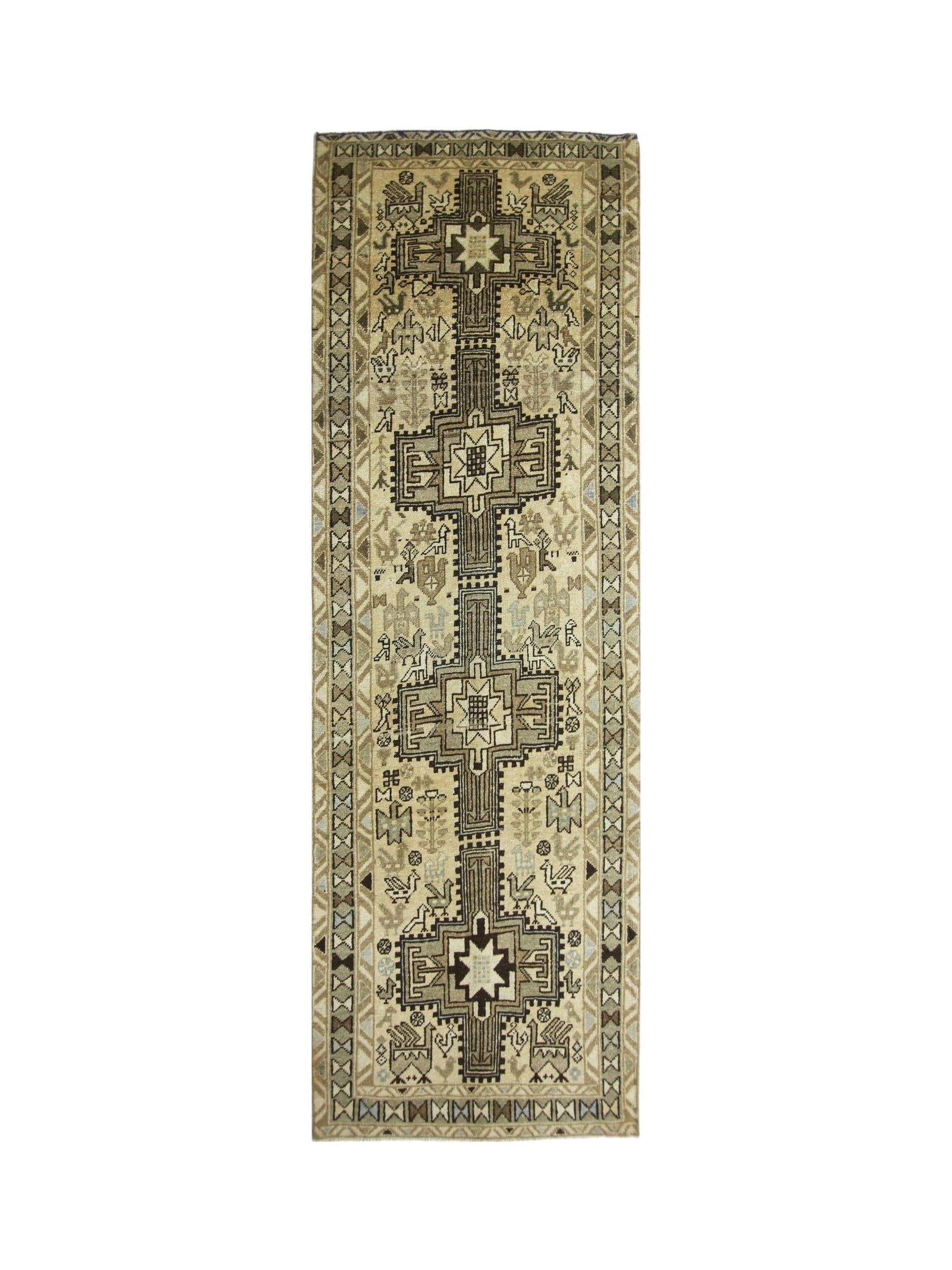 A vintage Persian Ardabil runner featuring a geometric central pole medallion and animal motifs.