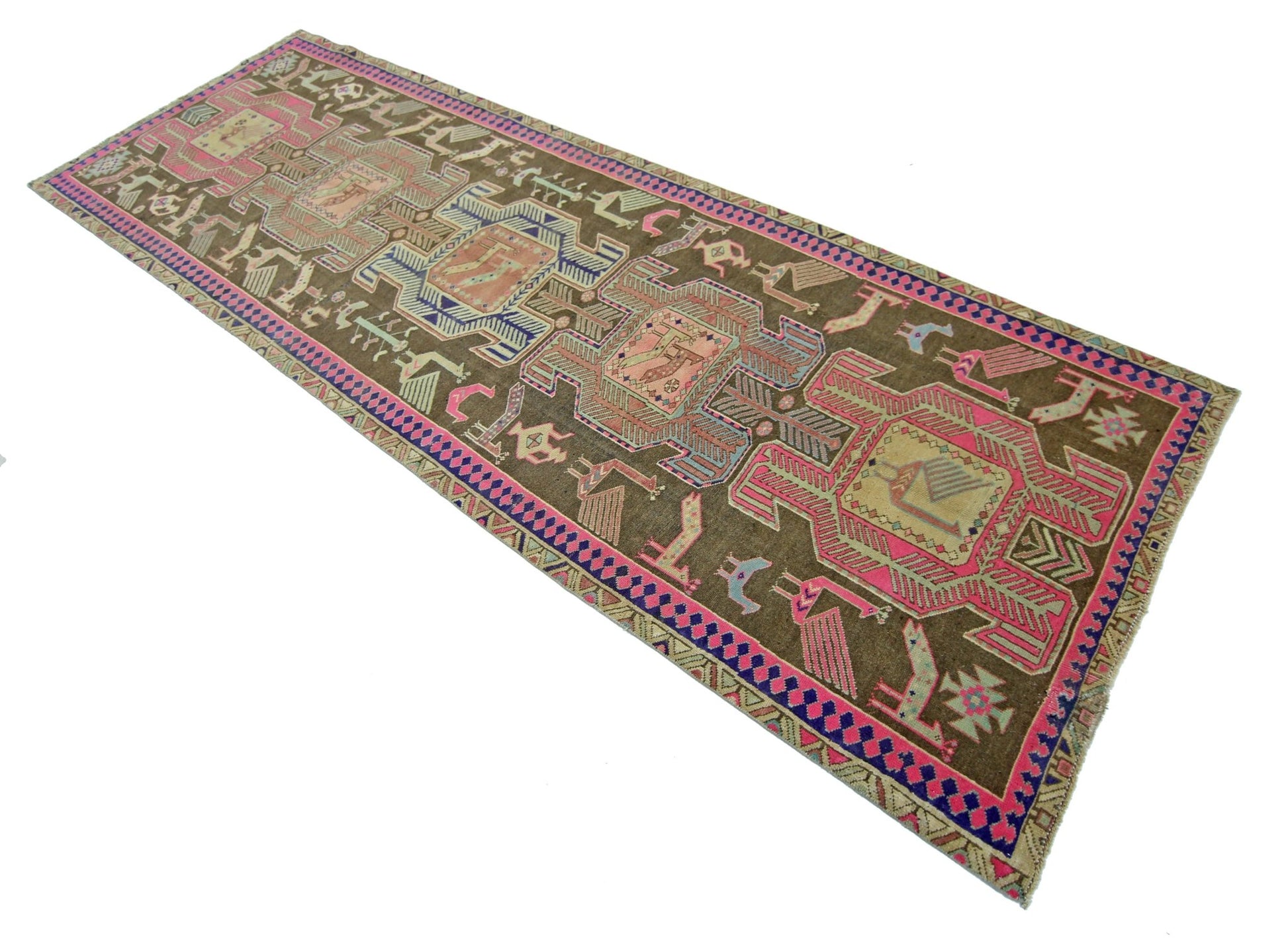 A vintage Persian Ardabil runner featuring geometric tribal motifs in pink, blue, and brown wool.