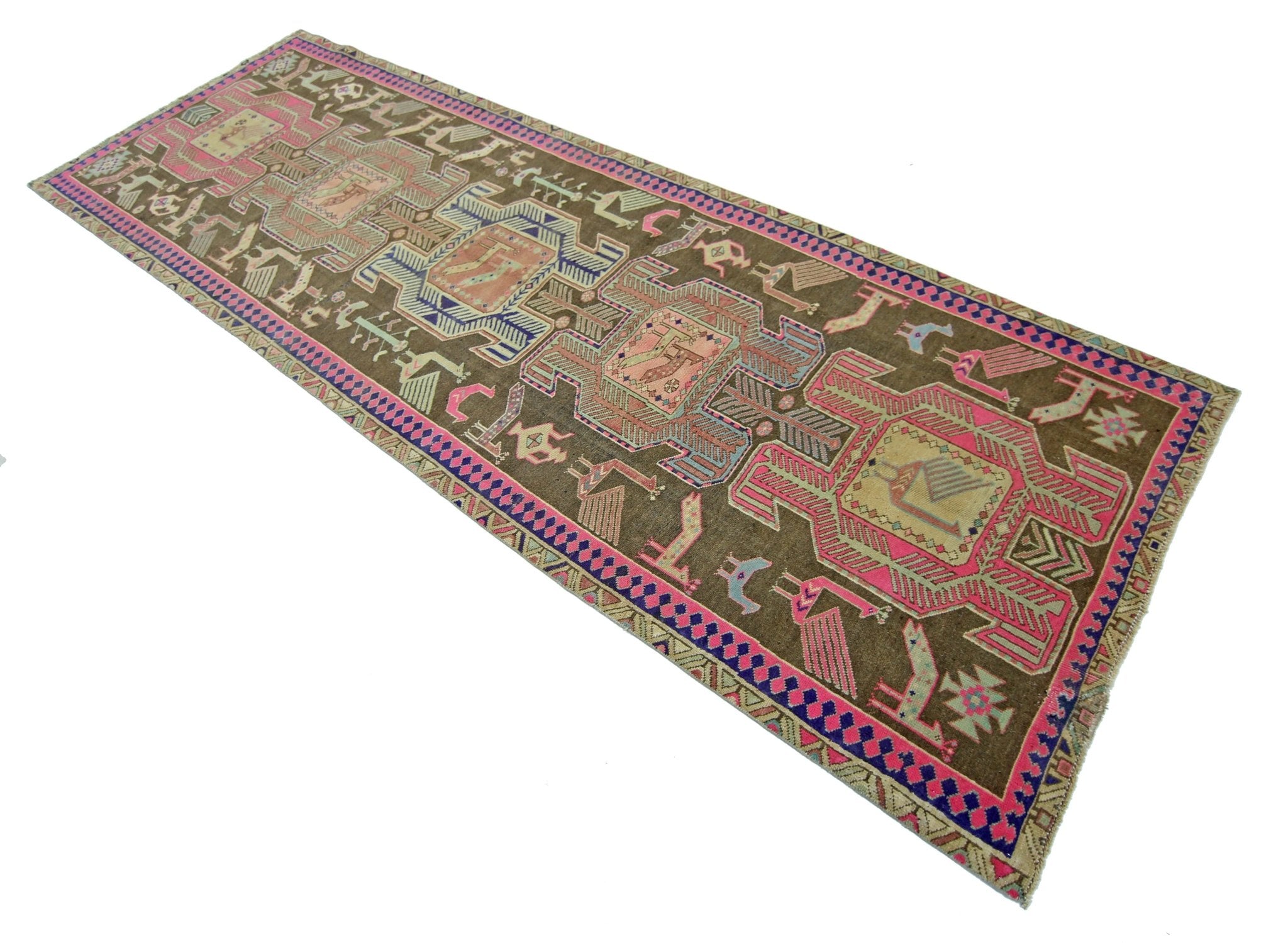 A vintage Persian Ardabil runner featuring geometric tribal motifs in pink, blue, and brown wool.
