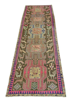 A vintage Persian Ardabil runner featuring geometric bird motifs in pink, blue, and brown wool.
