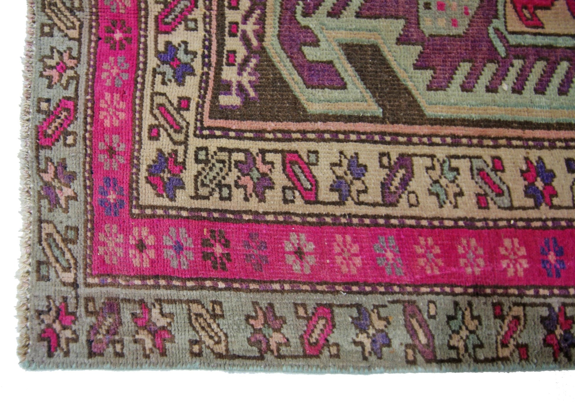 A vintage Persian Ardabil runner featuring a geometric pattern in vibrant pink, purple, and tan.
