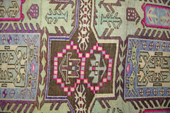 A vintage Persian Ardabil runner featuring intricate geometric patterns in vibrant wool colors.