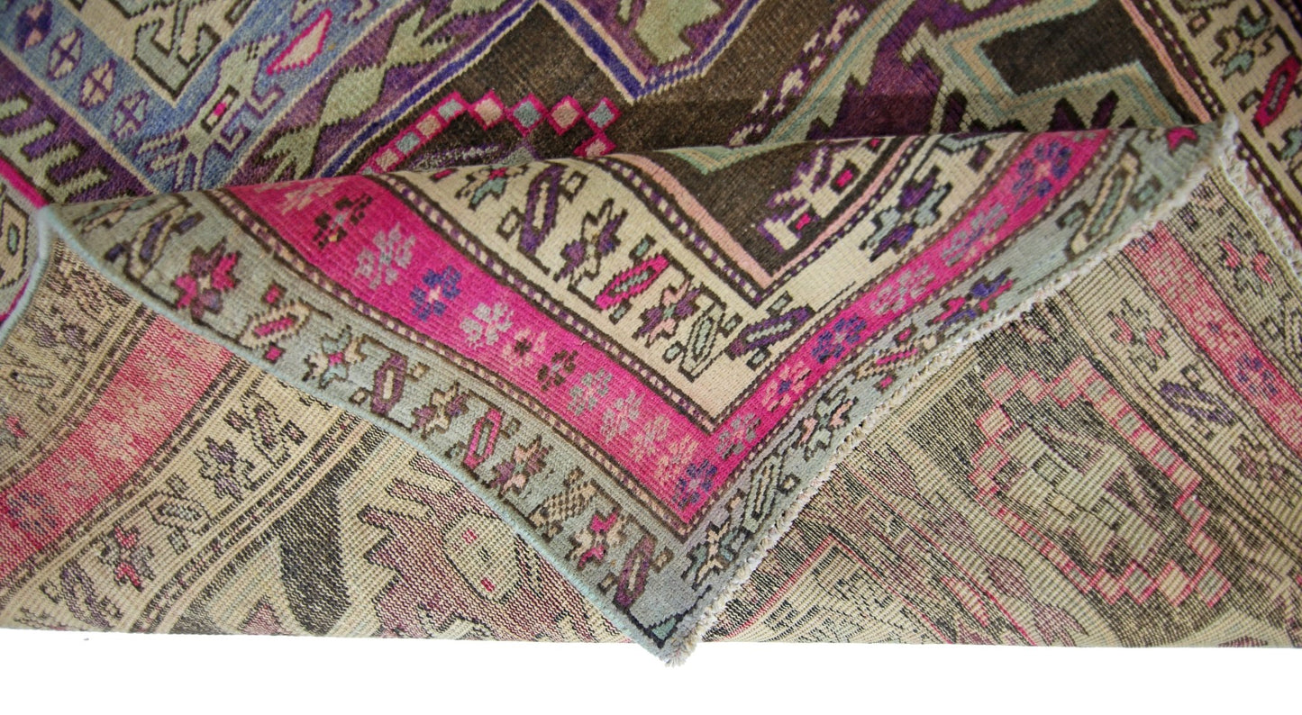 A vintage Persian Ardabil runner featuring a geometric pattern in vibrant pink, brown, and blue.