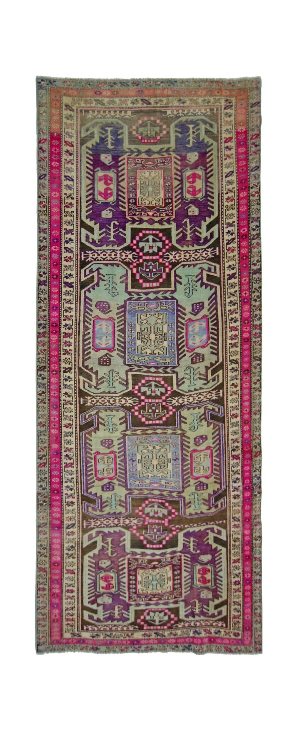 A vintage Persian Ardabil runner featuring a geometric pattern in vibrant purple, pink, and green.